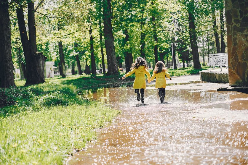 Kids in a rain coats. Children in a park. 